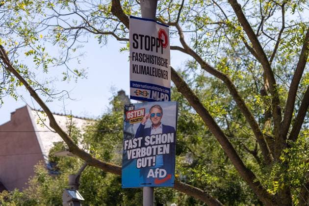 Landtagswahlkampf in Thüringen Ein Laternenmast in Erfurt ist mit zwei Wahlplakaten versehen. Oben befindet sich ein Plakat der MLPD mit der Aufschrift STOPPT FASCHISTISCHE KLIMALEUGNER. Darunter hängt ein Plakat der AfD mit dem Slogan FAST SCHON VERBOTEN GUT, das Bernd Höcke mit Sonnenbrille zeigt. Erfurt Altstadt Thüringen Deutschland *** State election campaign in Thuringia A lamp post in Erfurt is adorned with two election posters At the top is a poster for the MLPD with the words STOP FASCHISTIC CLIMATE DEVILS Below it hangs a poster for the AfD with the slogan FAST SCHON VERBOTEN GUT, showing Bernd Höcke with sunglasses Erfurt Old Town Thuringia Germany 20240815-6V2A6734