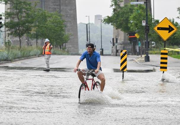 Kanada, Rohbruch sorgt für Überschwemmung in Montreal August 16, 2024, Montreal, Pq, Canada: A person bikes across a flooded street due to a water main break in Montreal, Friday, August 16, 2024, causing flooding in several streets of the area. Montreal Canada  - ZUMAc35_ 20240816_zaf_c35_008 Copyright: xGrahamxHughesx