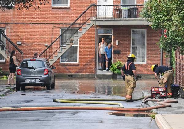 Kanada, Rohbruch sorgt für Überschwemmung in Montreal August 16, 2024, Montreal, Pq, Canada: Firefighters use hoses to drain water from a street after a watermain break on a street in Montreal, Friday, August 16, 2024, causing flooding in several streets of the area. Montreal Canada  - ZUMAc35_ 20240816_zaf_c35_011 Copyright: xGrahamxHughesx