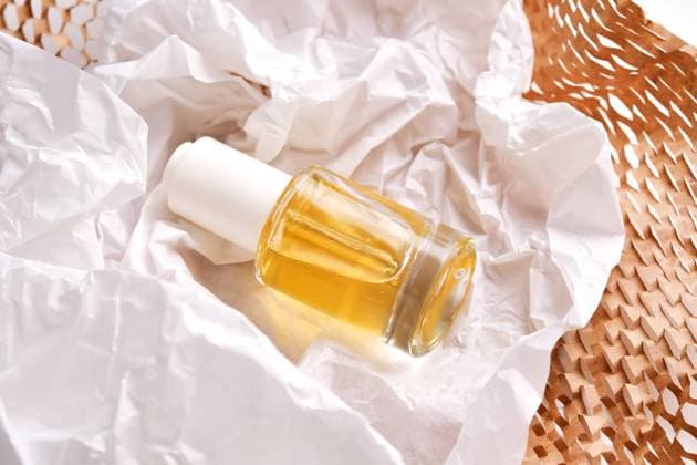 IMAGO Creative, Naturkosmetik Bottle with yellow serum on paper from the parcel. Bottle with yellow serum on paper from the parcel. High quality photo. Copyright: xZoonar.com MAREVGENNAx 21965081