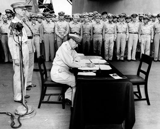 U.S. General Douglas MacArthur seated at desk during formal surrender ceremonies aboard USS Missouri as soldiers look on, Tokyo Bay, Japan, U.S. Army Signal Corps, September 2, 1945  Copyright: xCircaxImagesx ghi-circa12834