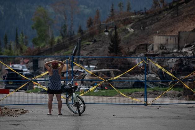 August 19, 2024, Jasper, Ab, CANADA: A cyclist takes in a heavily damaged neighbourhood as some residents return to Jasper, Alberta on Monday August 19, 2024. Wildfire caused evacuations and widespread damage in the National Park and Jasper townsite. Jasper CANADA  - ZUMAc35_ 20240819_zaf_c35_079 Copyright: xAmberxBrackenx