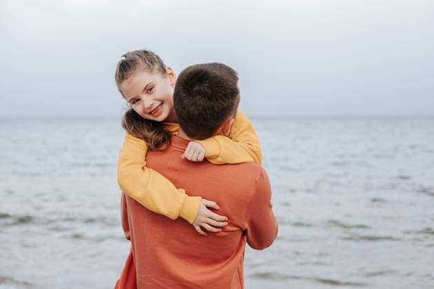 Creative Highlights Symbolbilder Father carrying daughter in arms at beach model released, Symbolfoto, HDF00140