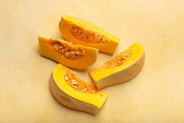 Butternut squash cut in halves lying on kitchen counter Pieces of butternut squash with seeds are lying on yellow countertop. Concept of healthy eating, autumn harvest and organic food Copyright: xZoonar.com OlenaxYeromenkox 22067110