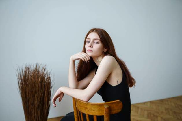 Creative Highlights Symbolbilder Young woman sitting on chair at home model released, Symbolfoto, VCF00153