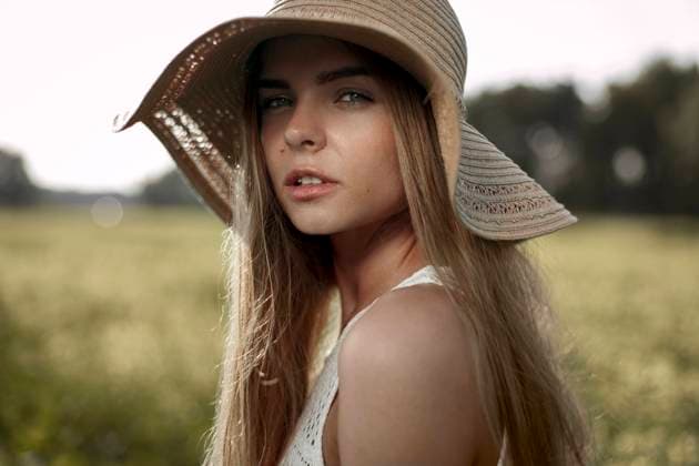 Creative Highlights Symbolbilder Beautiful woman wearing hat in field model released, Symbolfoto, VCF00170