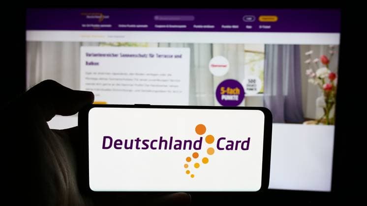 Person holding cellphone with logo of German customer loyalty company DeutschlandCard GmbH. Stuttgart, Germany - 07-15-2024: Person holding cellphone with logo of German customer loyalty company DeutschlandCard GmbH in front of business webpage. Focus on phone display. Copyright: xZoonar.com TimonxSchneiderx 22090993