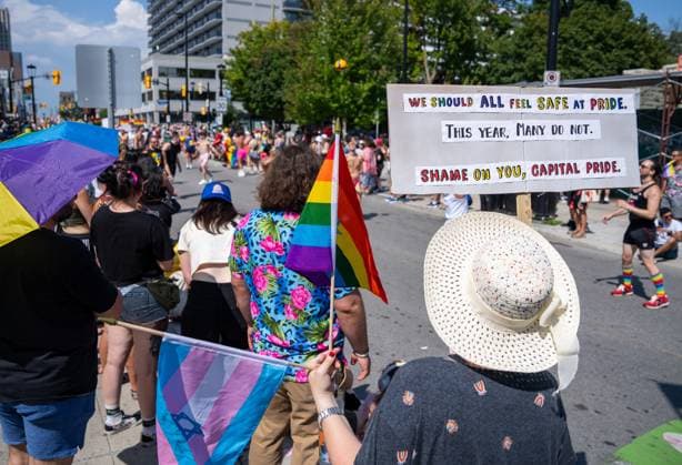 August 25, 2024, Ottawa, On, Canada: A spectator holds a sign directed at the organizers Capital Pride during the Capital Pride Parade in Ottawa, on Sunday, August 25, 2024. Ottawa Canada  - ZUMAc35_ 20240825_zaf_c35_033 Copyright: xChrisxTanouyex