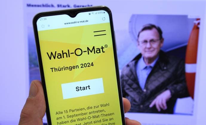 Auf einem Smartphone wurde der Wahl-O-Mat für die Landtagswahl in Thüringen geöffnet. Dahinter ist auf einem Bildschirm der Spitzenkandidat der Partei die Linke für die Wahl, Bodo Ramelow, zu sehen. Schnelsen Hamburg *** The Wahl O Mat for the state election in Thuringia was opened on a smartphone Behind it, the top candidate of the Left Party for the election, Bodo Ramelow, can be seen on a screen Schnelsen Hamburg