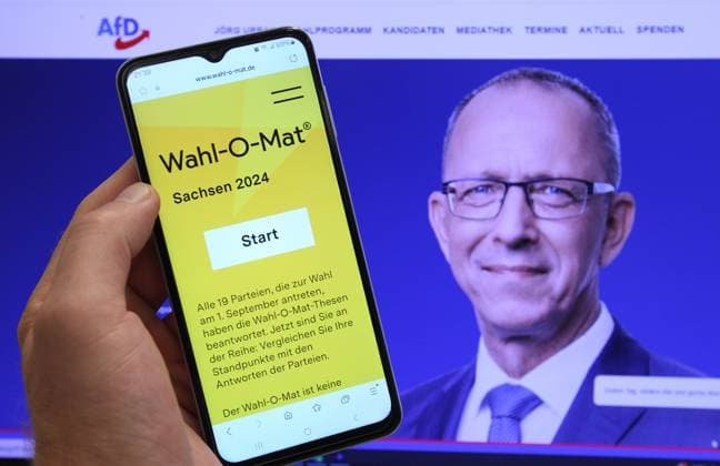 Auf einem Smartphone wurde der Wahl-O-Mat für die Landtagswahl in Sachsen geöffnet. Dahinter ist auf einem Bildschirm der Spitzenkandidat der Partei Alternative für Deutschland (AfD) für die Wahl, Jörg Urban, zu sehen. Schnelsen Hamburg *** The Wahl O Mat for the state election in Saxony was opened on a smartphone Behind it, the top candidate of the Alternative for Germany AfD party for the election, Jörg Urban, can be seen on a screen Schnelsen Hamburg