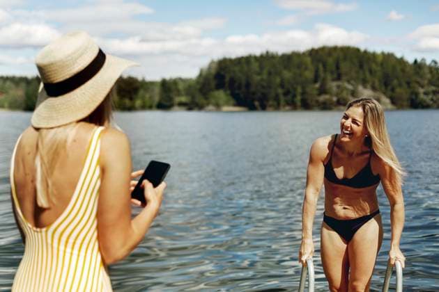 Woman photographing friend while bathing in lake , model released Copyright: xJohnerxImagesx , johner2499947.jpg 