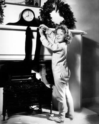 Shirley Temple, Publicity Portrait Hanging Christmas Stocking on Mantel, 1934  Copyright: xABxArchivex jtv007432