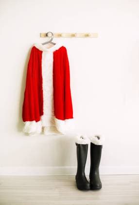 Santa Claus Kostüm hängt auf hölzernen Wand in der Nähe von Schuhen in hellen Raum. Saison celebraion cincept. Winterurlaub Santa Claus costume hanging on wooden wall near shoes in light room. Season celebraion cincept. Winter holiday Copyright: imageBROKER DashaxPetrenko ibxiqx09196178.jpg