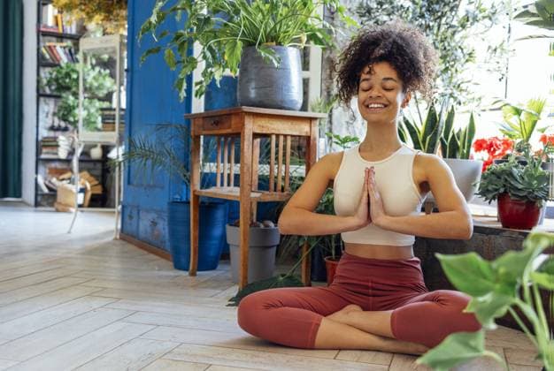 Junge Erwachsene glücklich fit schlank gesund afroamerikanischen ethnischen Frau trägt Sportkleidung in Yogapose zu Hause im Wohnzimmer sitzen, tun Fitness Morgen Workout Übungen Ausbildung Young adult happy fit slim healthy African American ethnic woman wearing sportswear sitting in yoga pose at home in living room, doing fitness morning workout exercises training Copyright: imageBROKER DashaxPetrenko ibxiqx09201736.jpg ,model released, Symbolfoto ,property released