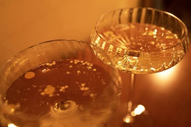 Zwei Gläser mit Champagner auf einer hölzernen Tischoberfläche. Sie reflektieren sanfte Sonnenstrahlen. Sekt mit schönen Bokeflecken. Raum kopieren. Nahaufnahme Two glasses with champagne on a wooden table surface. They are reflecting soft sunshine rayson. Sparkling wine with beautiful boke spots. Copy space. Close up Copyright: imageBROKER DashaxPetrenko ibxiqx09201963.jpg