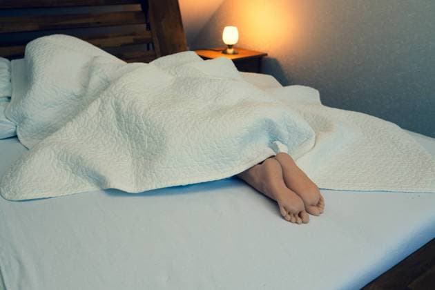 Beautiful feet under the white blanket. Relaxation of a woman in Detmold, North Rhine-Westphalia, Germany R_TPQE240829-1526948-01