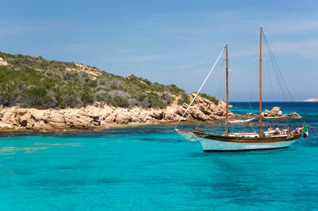 Wooden sailing boat anchored in clear turquoise water off Cala Granara, Spargi Island, La Maddalena Archipelago National Park, Sassari, Sardinia, Italy, Mediterranean, Europe Copyright: DavidxTomlinson 1310-383 RECORD DATE NOT STATED