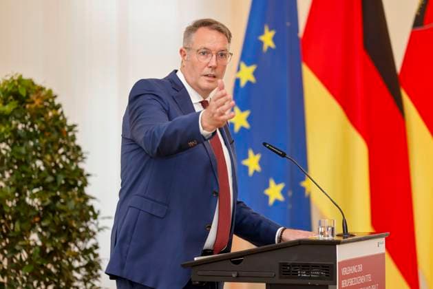 Rhineland-Palatinate Minister President Alexander Schweitzer at the lectern in front of flags in the State Chancellery of Rhineland-Palatinate Speech on the occasion of the awarding of professional titles of the state 03 09 24