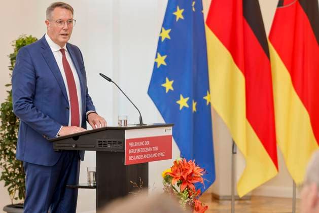 Rhineland-Palatinate Minister President Alexander Schweitzer at the lectern in front of flags in the State Chancellery of Rhineland-Palatinate Speech on the occasion of the awarding of professional titles of the state 03 09 24