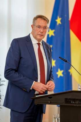 Rhineland-Palatinate Minister President Alexander Schweitzer at the lectern in front of flags in the State Chancellery of Rhineland-Palatinate Speech on the occasion of the awarding of professional titles of the state 03 09 24