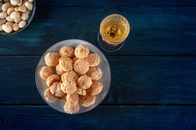 Amaretti, traditionelles italienisches Mandelgebäck, mit einem Glas Amaretto Likör, Aufnahme von oben mit Platz für Text auf dunkelblauem Holzhintergrund Amaretti, traditional Italian almond cookies, with a glass of Amaretto liqueur, shot from the top with a place for text on a dark blue wooden background Copyright: imageBROKER KaterinaxSolovyeva ibxiqx09657320.jpg