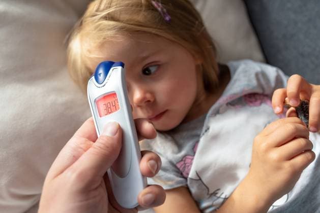 Mutter mißt die Temperatur ihres Kindes mit einem Infrarot Thermometer zu Hause, mittleres Fieber Mutter hält digitales Infrarot Thermometer in der Hand Mother takes temperature for her child with infrared thermometer at home, medium grade fever Mother hand holding digital infrared thermometer Copyright: imageBROKER PrzemyslawxIciak ibxiqx09673995.jpg ,model released, Symbolfoto ,property released