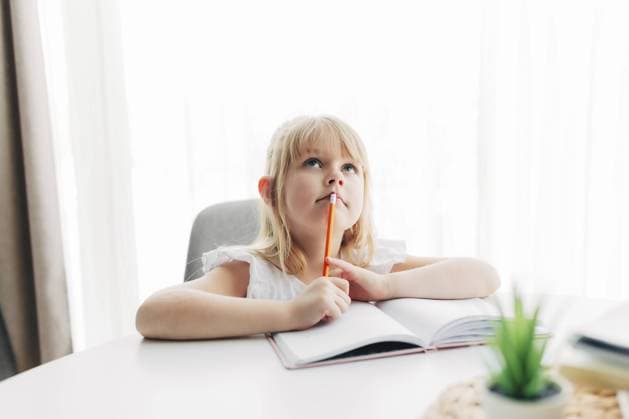 Creative Highlights Symbolfotos Ein kleines Mädchen sitzt am Tisch und schreibt in ein weißes Notizbuch. Das Mädchen hat den Finger gehoben, hat eine Idee oder hat ein Ergebnis. Bildungskonzept. Hausunterricht. Hausaufgaben. Mädchen denkt über Aufgabenlösung nach A little girl sits at the table and writes in a white notebook. Girl raised her finger, have an idea or got a result. Education concept. Home schooling. Homework. Girl is thinking on task solution Copyright: imageBROKER LenaxIvanova ibxiqx11147641.jpg ,model released, Symbolfoto ,property released