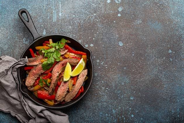 IMAGO Creative, Food, Fajita Traditionelles mexikanisches Gericht Rindfleisch Fajitas mit Paprika in schwarzem Gusseisen Pfanne auf rustikalen Stein Hintergrund von oben mit Platz für Text, American Mexican Food Traditional Mexican dish Beef fajitas with bell peppers in black cast iron pan on rustic stone background from above with space for text, American Mexican food Copyright: imageBROKER OlenaxYeromenko ibxiqx08607108.jpg