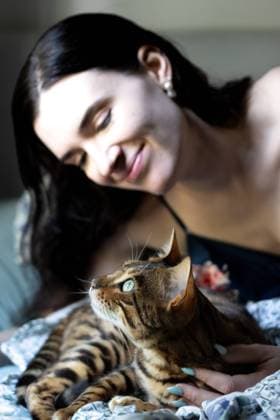 Creative Highlights Symbolfotos Bengal cat looks up while serene woman lovingly holds it Kelowna, British Columbia, Canada R_PESF240909A-1520933-01 ,model released, Symbolfoto