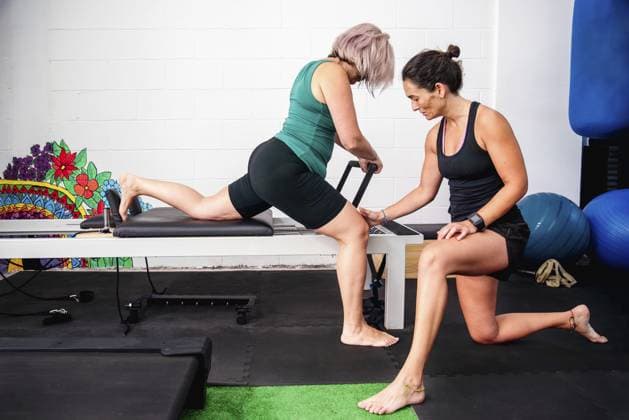 Eine Frau auf einem Pilates Reformer bei einer Übung unter Anleitung eines Trainers A woman on a Pilates reformer performing an exercise under the guidance of a trainer Copyright: imageBROKER JuanmaxCuevas ibxjcu10756131.jpg ,model released, Symbolfoto ,property released