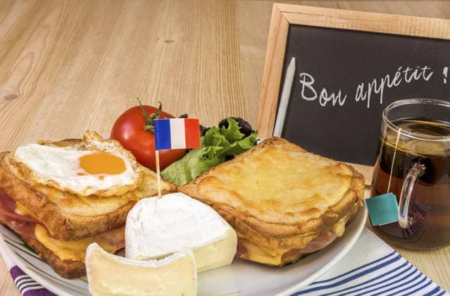 Traditionelle französische Sandwiches, Croque Madame und Croque Monsieur, feiner Käse und frischer Salat, auf dem Tisch platziert und daneben eine Kreidetafel mit der Botschaft bon appetit Traditional french sandwiches, croque madame and croque monsieur, fine cheese and fresh salad, placed on table and near it a chalkboard with the message of bon appetit Copyright: imageBROKER DanielaxSimonaxTemne ibxiqx11334138.jpg