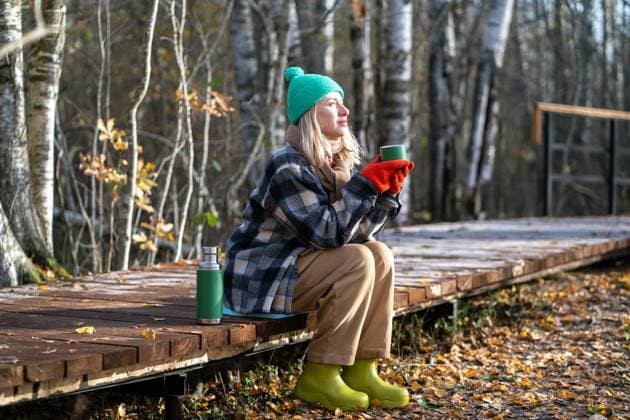 Time alone. Relaxed middle aged woman enjoy calm weekend in fall park meditative drinks thermos tea. Satisfied middle aged woman spending tranquility time alone walking in autumn forest dreaming drinking hot thermos tea. Relaxed pleased female rest on eco path enjoys calm late fall park, stress free. ,model released, Symbolfoto Copyright: xZoonar.com DmitriixMarchenkox 22157438 ,model released, Symbolfoto ,property released