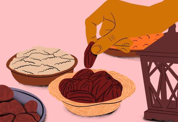 Hand selecting a date from a bowl in a traditional meal setup. Tradition, Indulgence, Ramadan, Festivity, Togetherness Hand picking a date from a bowl with other dry fruits and traditional lantern on a pink background. sham00317 Copyright: xConnectxImagesx