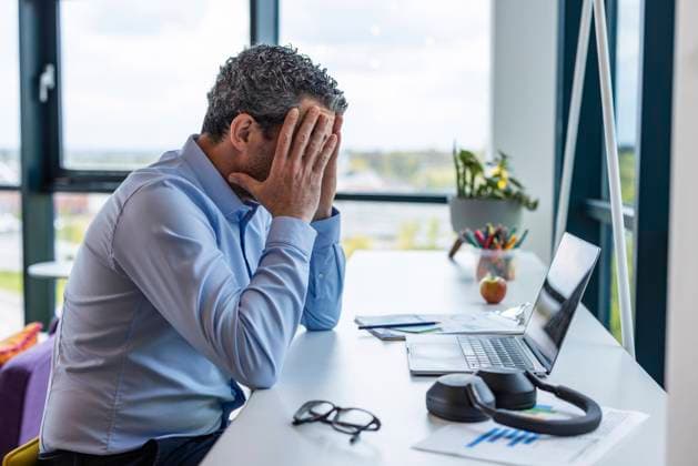 Frustrated businessman sitting near desk at co working space model released, Symbolfoto property released, WPEF09302