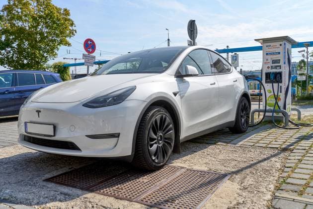 Munich, Bavaria, Germany - September 23, 2024: A white Tesla Model Y charges at a public charging station in Munich