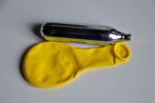 Nitrous oxide in Marseille, France. In this photo illustration, a yellow balloon and a nitrous oxide cartridge are placed on a white table. Nitrous oxide, nicknamed laughing gas , is a new drug that is attracting more and more adolescents. France Copyright: xGerardxBottinox xSOPAxImagesx 2024_10_01_nitrous_oxide_DSC_1991_r