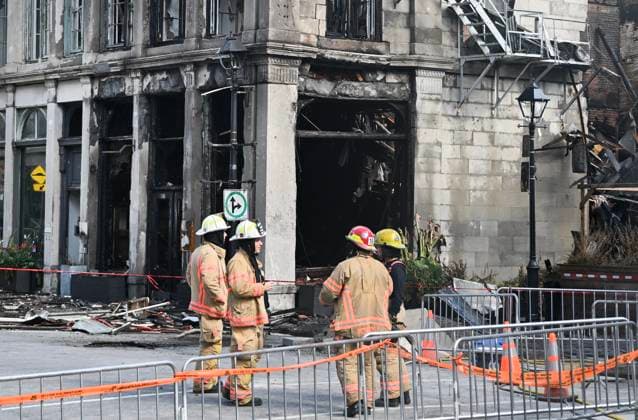 October 5, 2024, Montreal, Pq, Canada: Firefighters next to a building following a fatal fire in Old Montreal on Saturday, Oct., 5, 2024, which left two people dead. Montreal Canada  - ZUMAc35_ 20241005_zaf_c35_070 Copyright: xGrahamxHughesx