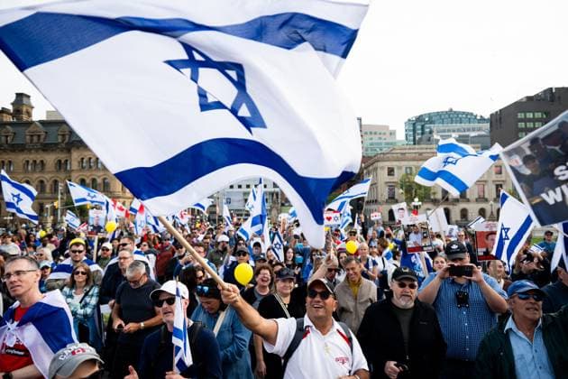 October 6, 2024, Ottawa, On, Canada: A Pro-Israel protestor waves an Israeli flag during a commemorative ceremony in Ottawa on Sunday, Oct. 6, 2024. Monday marks one-year since the beginning of hostilities between Israel and Palestine. Ottawa Canada  - ZUMAc35_ 20241006_zaf_c35_008 Copyright: xSpencerxColbyx