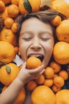 Creative Highlights Symbolfotos Portrait of a boy s face laying down in tangerines Shanghai, Shanghai, China CR_ITUP241004-1541866-01 ,model released, Symbolfoto