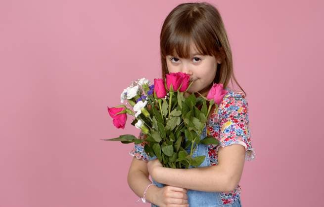Sweet adorable young little girl holding bunch of fresh spring flowers. Wearing dungarees Sweet adorable young little girl holding bunch of fresh spring flowers. Wearing dungarees. Isolated in pink background. ,model released, Symbolfoto Copyright: xZoonar.com DanielxDashx 15396283 ,model released, Symbolfoto ,property released