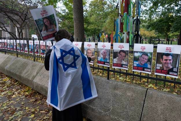 October 7, 2024, Montreal, Pq, Canada: A woman looks at pictures of Israeli hostages during a pro-Israel vigil on the anniversary of a Hamas attack on Israel that triggered the ongoing war in Gaza in front of McGill University, in Montreal, Monday, Oct. 7, 2024. Montreal Canada  - ZUMAc35_ 20241007_zaf_c35_012 Copyright: xRyanxRemiorzx