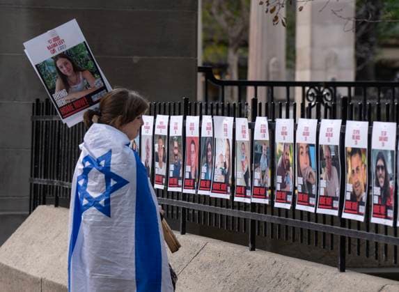 October 7, 2024, Montreal, Pq, Canada: A woman looks at pictures of Israeli hostages during a pro-Israel vigil on the anniversary of a Hamas attack on Israel that triggered the ongoing war in Gaza in front of McGill University, in Montreal, Monday, Oct. 7, 2024. Montreal Canada  - ZUMAc35_ 20241007_zaf_c35_032 Copyright: xRyanxRemiorzx