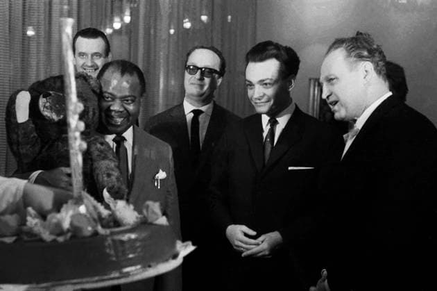 Louis Armstrong - Tournee durch die DDR Der amerikanische Jazzmusiker Louis Armstrong bekommt eine Schokoladentorte serviert bei seiner Ankunft in Ost-Berlin im Rahmen seiner Tournee durch die DDR 1965. Als Zweiter von rechts ist Ernst Zielke abgebildet, Generaldirektor der für die Tour zuständigen Künstleragentur. Ost-Berlin Deutsche Demokratische Republik *** Louis Armstrong Tour through the GDR the American Jazz musician Louis Armstrong gets a Chocolate cake served at its Arrival in East Berlin at Frame its Tour through the GDR 1965 as Second from right is Ernst Zielke pictured, General Manager the for the Tour Responsible artist agency East Berlin German Democratic Republic Copyright: TassiloxLeher LEH_91010000041 Nur redaktionelle Nutzung. Editorial usage only. EDITORIAL USE ONLY