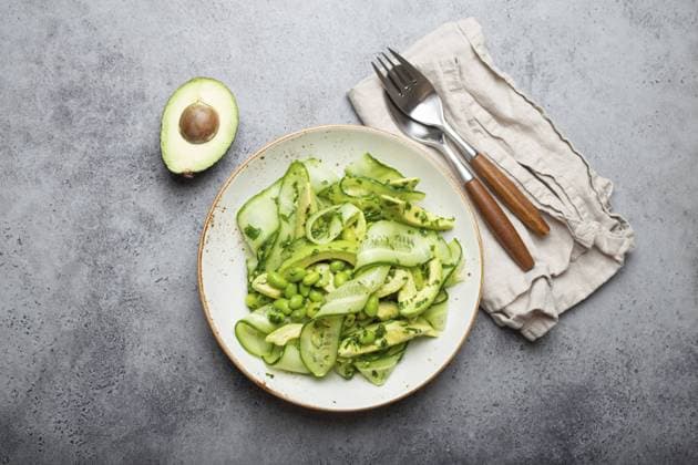 Gesunde vegane grüne Avocado Salatschüssel mit geschnittenen Gurken, Edamame Bohnen, Olivenöl und Kräutern auf Keramikteller Draufsicht auf grauem Stein rustikalen Tisch Hintergrund, Food Fotografie Healthy vegan green avocado salad bowl with sliced cucumbers, edamame beans, olive oil and herbs on ceramic plate top view on grey stone rustic table background, food photography, food photography Copyright: imageBROKER OlenaxYeromenko ibxiqx11318830.jpg