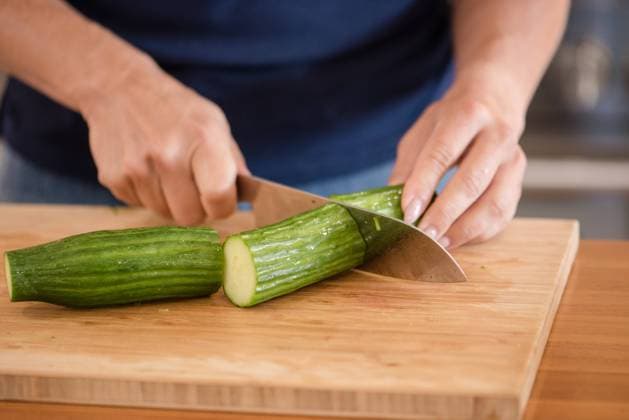 Close up of a womans hands chopping a cucumber Napa, California, United States R_HOOX241007-1551581-01 ,model released, Symbolfoto