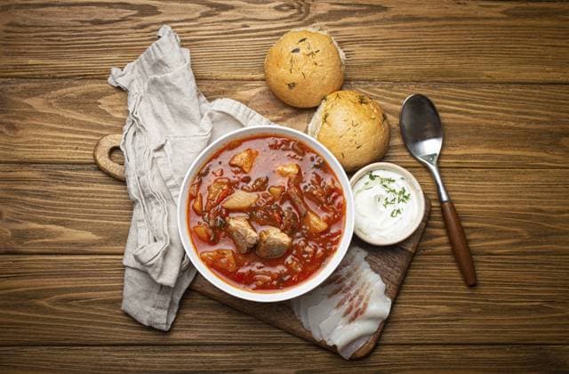 Ukrainischer Borschtsch, Rote Bete Suppe mit Fleisch, in weißer Schale mit saurer Sahne, Knoblauchbrötchen Pampushka und Salo Scheiben auf rustikalem Steinhintergrund. Traditionelle authentische Gericht der Ukraine, Food Fotografie, food photography, food photography Ukrainian Borscht, red beetroot soup with meat, in white bowl with sour cream, garlic buns Pampushka and salo slices on rustic stone background. Traditional authentic dish of Ukraine, food photography, food photography Copyright: imageBROKER OlenaxYeromenko ibxiqx11317768.jpg