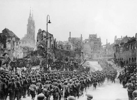 Orig. caption... 7TH ARMY CELEBRATE CAPTURE OF NUREMBERG. Less than 24 hours after the capture of Nuremberg, men of the 7th Army raised the Stars and Stripes in the Adolf Hitler Platz in the old part of the city, surrounded by ruins which still amouldered. Lt. General Alexander Patch, Commander-in-Chief of the 7th Army personally thanked the men who made the spectacular capture. Picture shows: The troops who helped to capture Nuremberg double out of the Adolf Hitler Platz, after passing the saluting base after the ceremony. Note. American 7, Army troops capture Nuremberg 4 20 45. Note CD119 sites: GERMANY; USA*; NUREMBERG sp_sw x5600x *** Orig caption 7TH ARMY CELEBRATE CAPTURE OF NUREMBERG Less than 24 hours after the capture of Nurember  Copyright: xXxXxXx THE AMERICANS CONQUER NUREMBERG