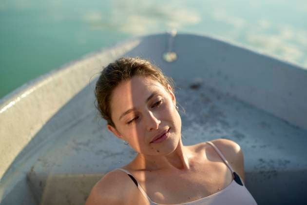 Creative Highlights Symbolfotos Woman relaxing in a boat with gentle sunlight on her face. bola03228 Copyright: xConnectxImagesx ,model released