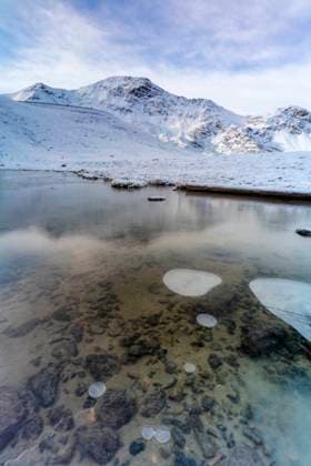 Snowy mountains reflected in a frozen lake, Braulio Valley, Valtellina Bormio, Lombardy, Italy CR_ROMO240611-1454353-01