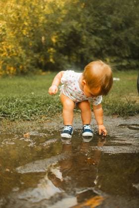 Toddler putting hands and feet in mud puddle Raleigh, North Carolina, United States R_XMBF241014-1562486-01 ,model released, Symbolfoto